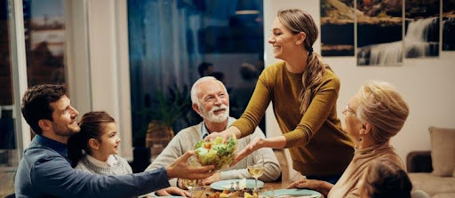 Multi‑generational family enjoying dinner together, showcasing respect, gratitude, and shared traditions central to JMIS ethos.